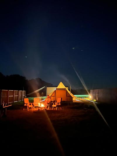 People sitting outside their Bell Tent enjoying Glamping in Norfolk